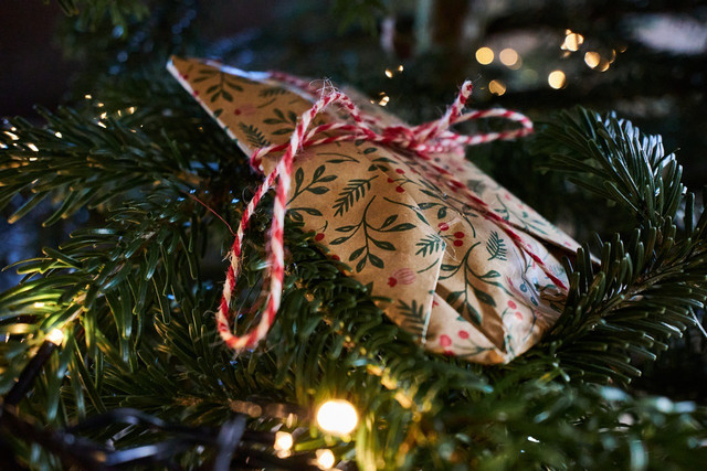 Using ribbons or hiding them among the branches are some ways to hold gifts on a tree.