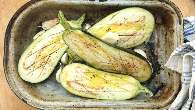Roasted garlic is never a bad accompaniment to roasted eggplant. Simply squeeze the flesh out once cooked.