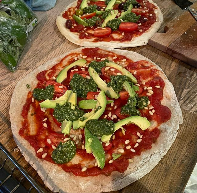 A vegan pizza topped with wild garlic pesto, pine nuts and avocados.