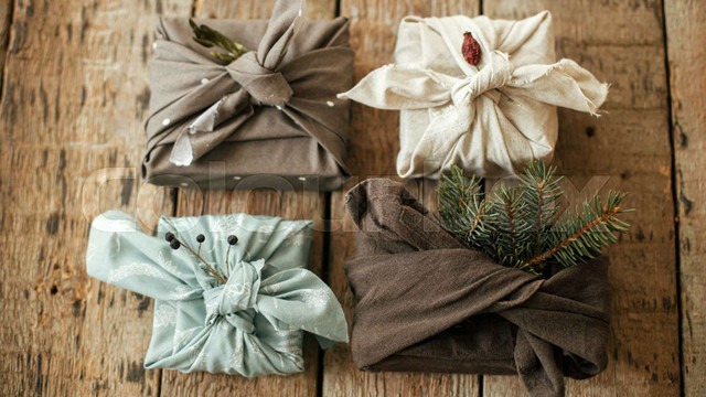 Four square gifts wrapped in fabric and tied with decorative knots.